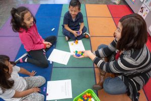 Kindergarteners use number cubes.